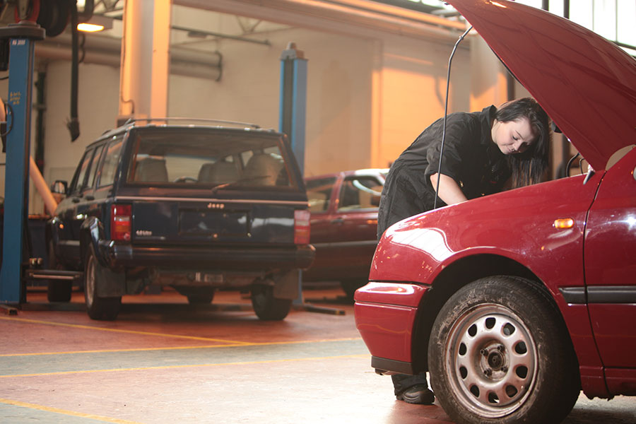 Student working on the engine of a car